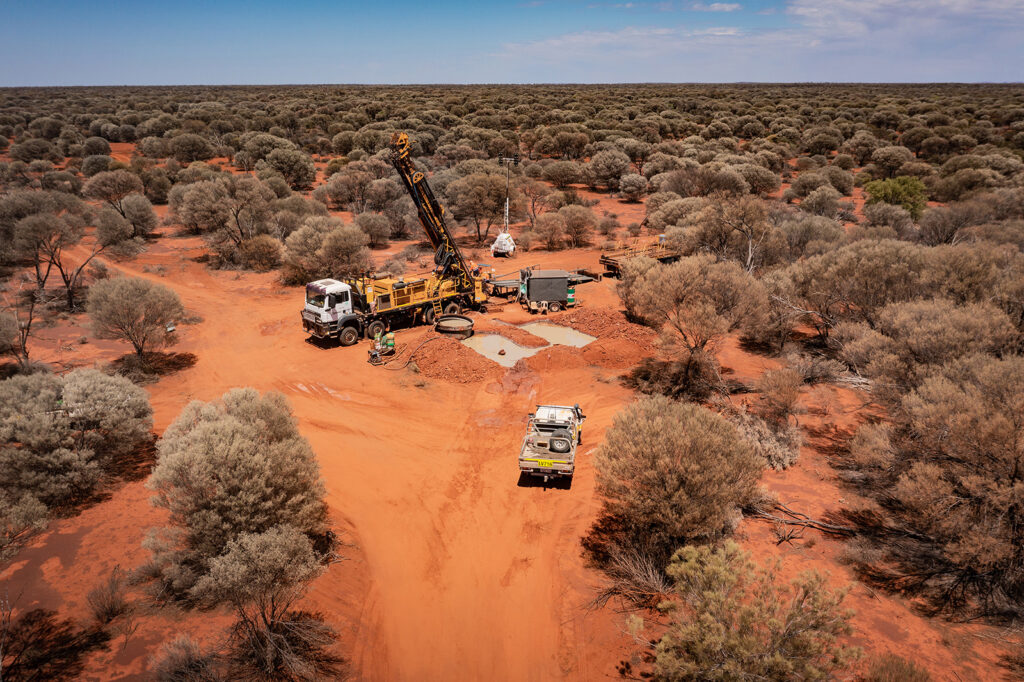 Aerial view of a remote drilling operation in an arid Australian landscape.