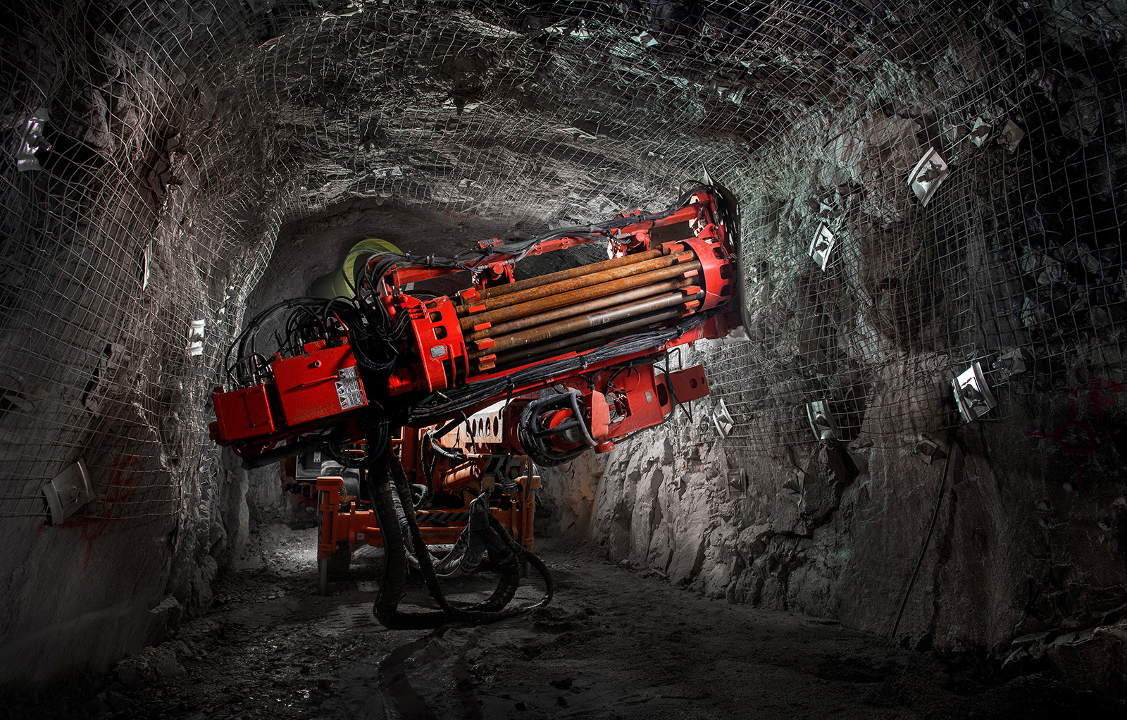 Underground drilling rig operating inside a reinforced tunnel.